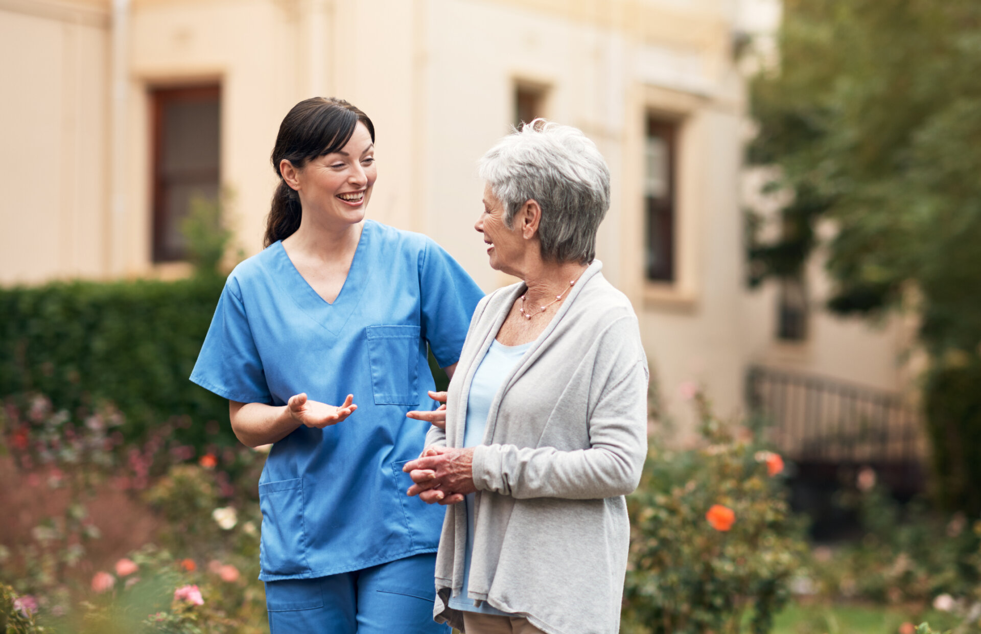 Senior memory care resident walking outdoors with her caregiver at Traditions at Hunter Station in Sellersburg, Indiana