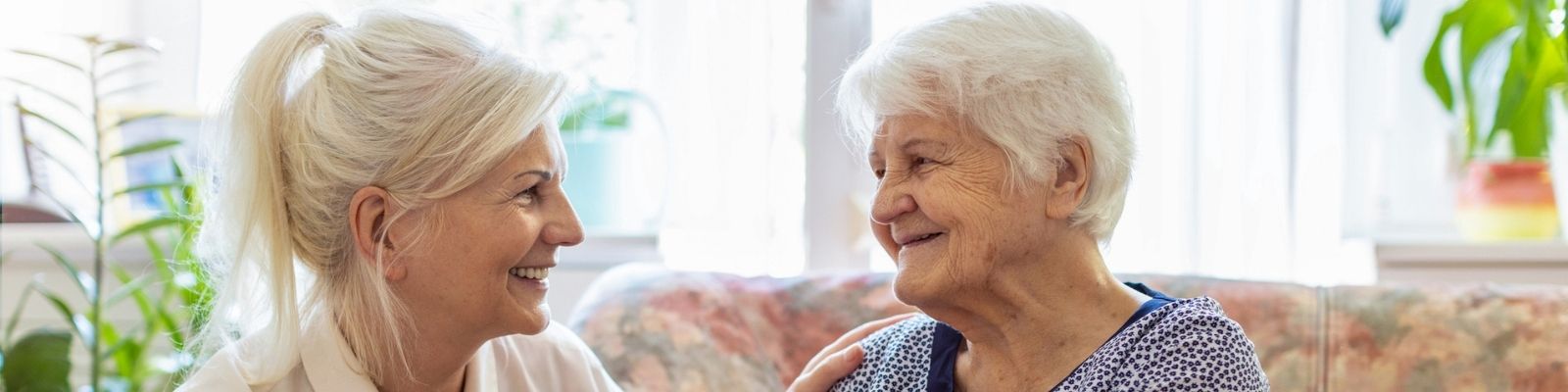 Two woman engaged in conversation in memory care apartment