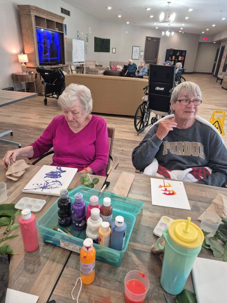 Residents creating colorful artwork during a painting activity at Traditions at Hunter Station